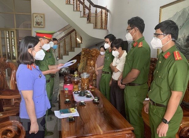 Đại diện Cơ quan Cảnh sát điều tra đọc lệnh khởi tố, bắt tạm giam ông Đoàn Thế Nam (áo trắng, giữa, bên phải), nguyên Hiệu trưởng Trường Cao đẳng Nghề Bình Phước. (Ảnh: TTXVN) ảnh 1 truong-cao-dang-nghe-binh-phuoc(1).jpg